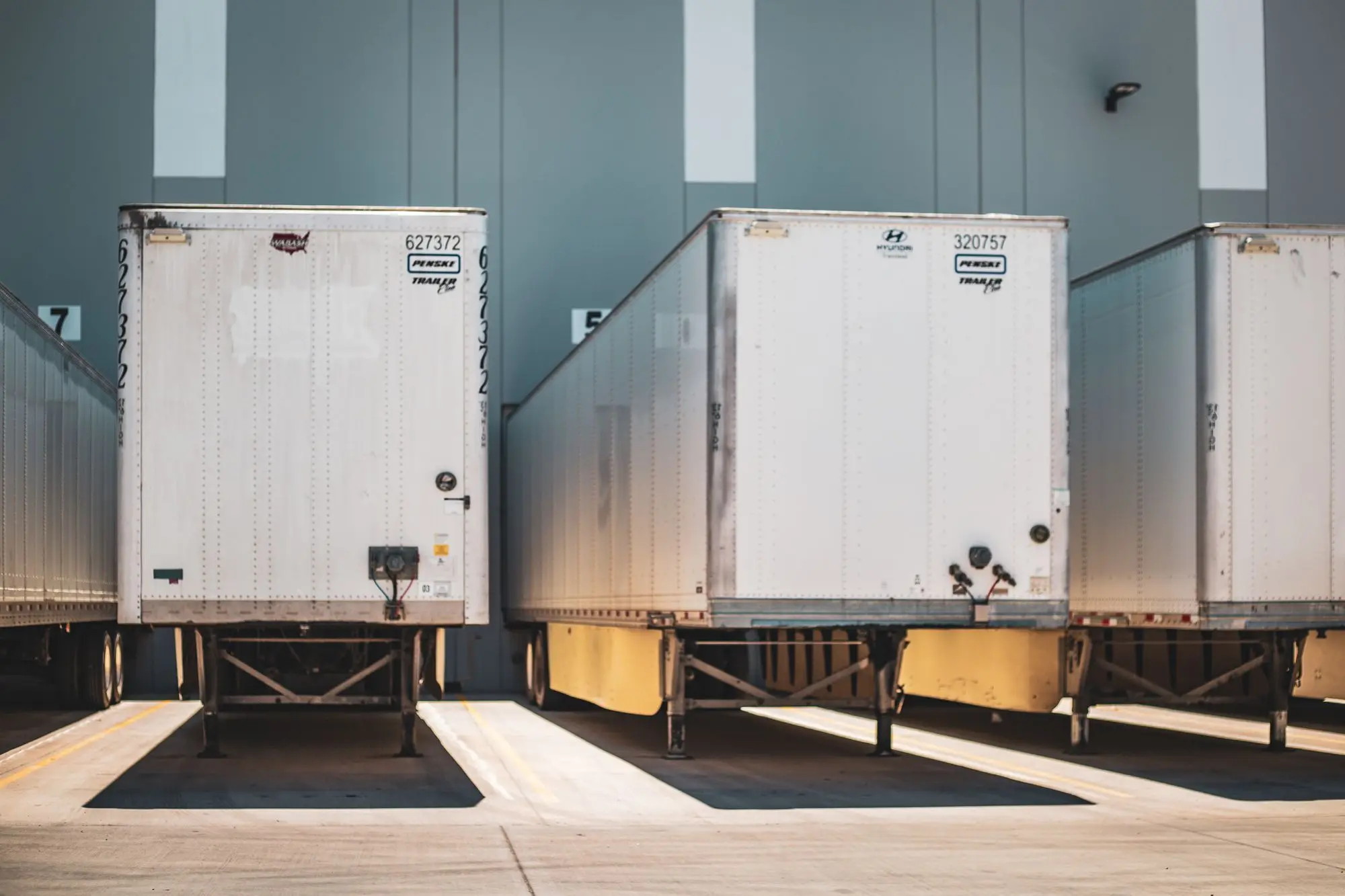 A row of freight trailers backed onto a commercial loading dock.