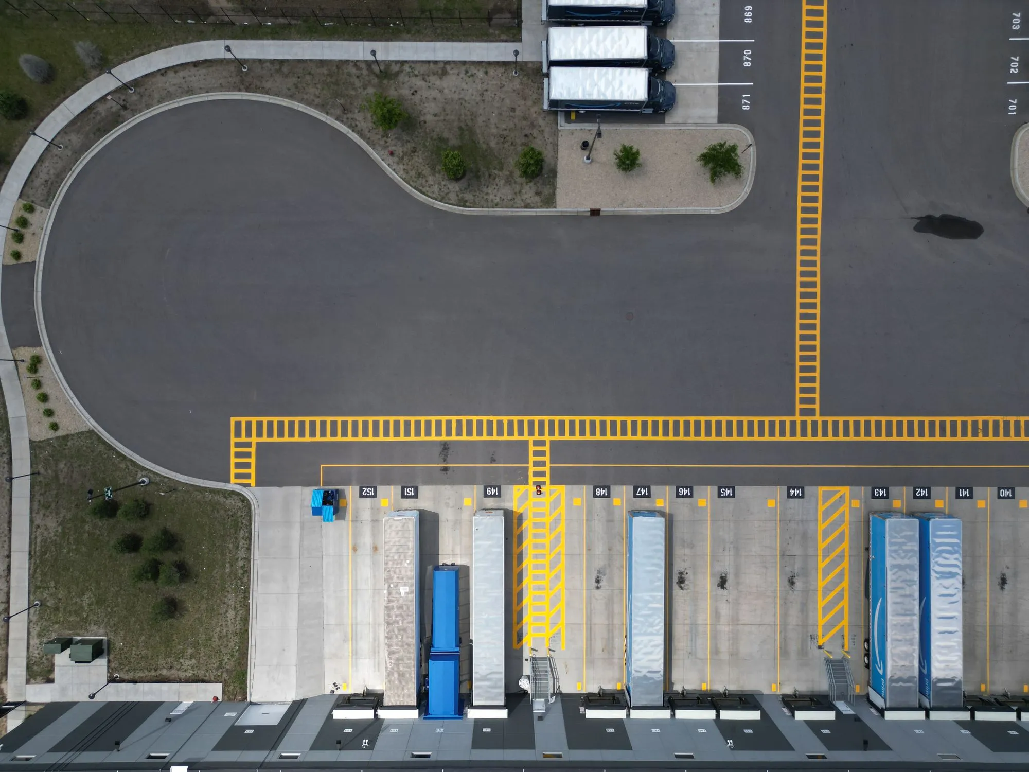 Overhead view of trucks parked at loading dock bays.